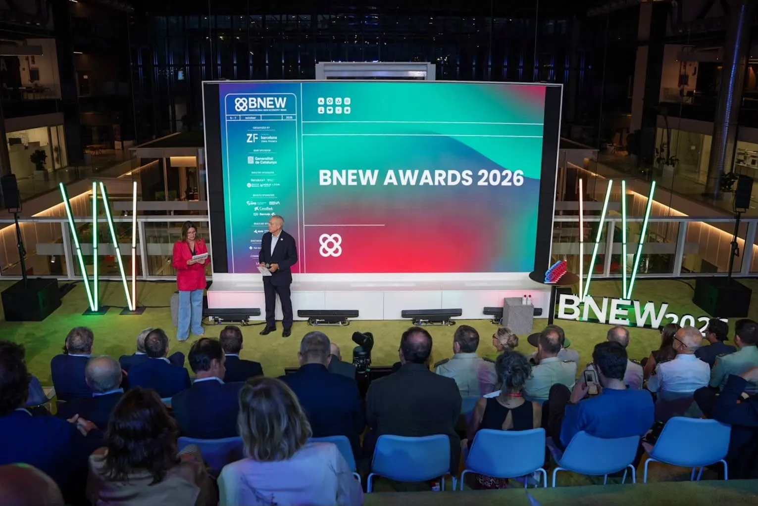 Pere Navarro i Blanca Sorigué a l’escenari dels BNEW Awards 2026, davant d’una pantalla gran i el públic assegut
